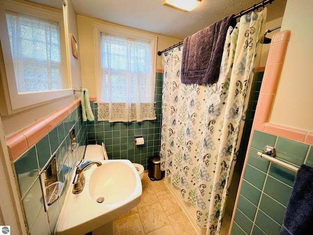 801 N Bridge St, Bellaire, MI 49615 - full bath featuring tile walls, curtained shower, a wainscoted wall, and a textured ceiling