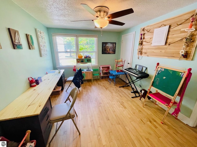 801 N Bridge St, Bellaire, MI 49615 - rec room with a textured ceiling, wood-type flooring, and a ceiling fan