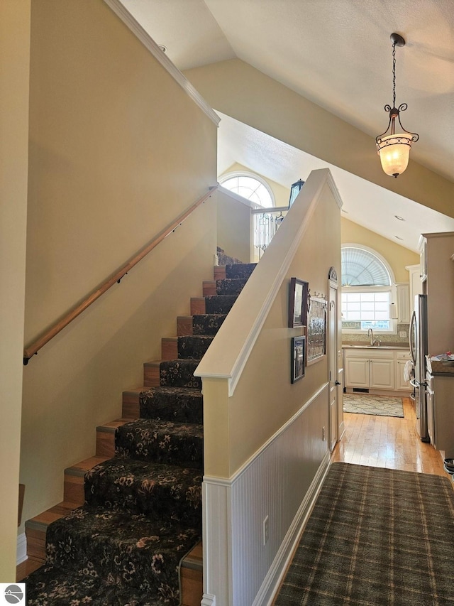 1005 W Lake St Unit 4, Tawas City, MI 48763 - staircase featuring lofted ceiling and wood finished floors