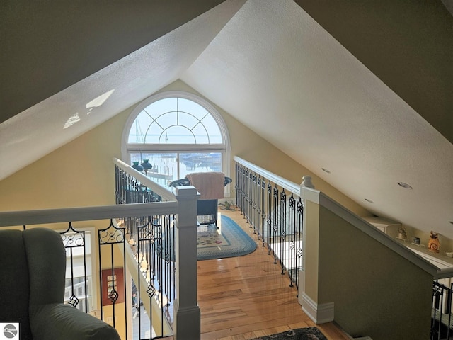 1005 W Lake St Unit 4, Tawas City, MI 48763 - corridor with lofted ceiling, wood finished floors, an upstairs landing, and a textured ceiling