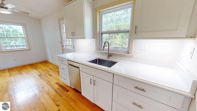 7500 Five Lakes Dr, Farwell, MI 48622 - kitchen with dishwasher, light countertops, light wood-style floors, a ceiling fan, and white cabinetry