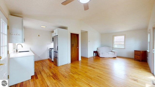 7500 Five Lakes Dr, Farwell, MI 48622 - kitchen featuring stainless steel appliances, light wood-style floors, lofted ceiling, ceiling fan, and white cabinets