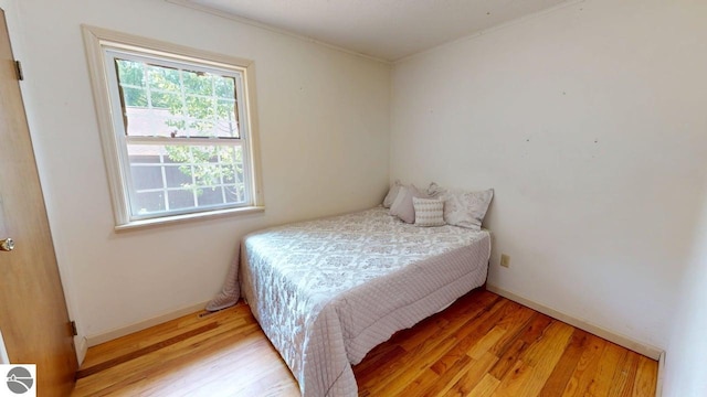 7500 Five Lakes Dr, Farwell, MI 48622 - bedroom with light wood-type flooring and crown molding