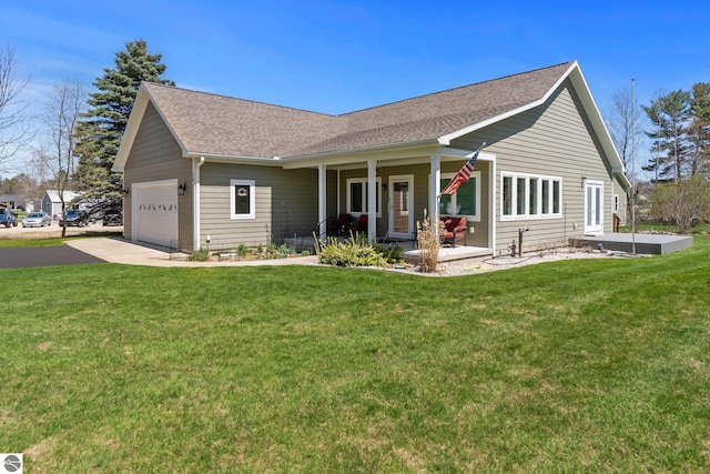 301 Pearl St, Kingsley, MI 49649 - view of front facade with a porch, a front lawn, asphalt driveway, a shingled roof, and a garage