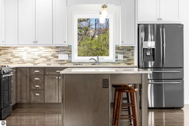 301 Pearl St, Kingsley, MI 49649 - kitchen featuring stainless steel refrigerator with ice dispenser, gas range oven, light countertops, and white cabinetry