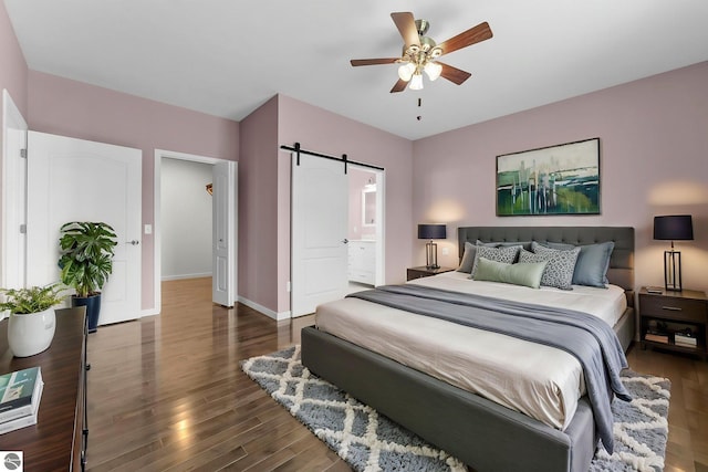 301 Pearl St, Kingsley, MI 49649 - bedroom with a barn door, wood finished floors, a ceiling fan, and ensuite bathroom