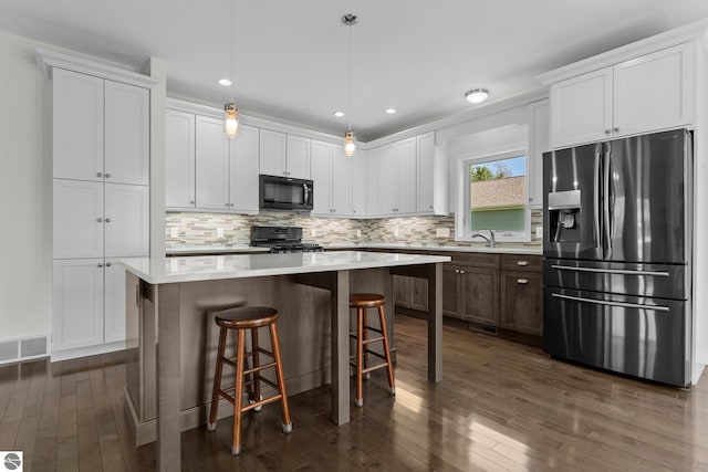 301 Pearl St, Kingsley, MI 49649 - kitchen with stainless steel refrigerator with ice dispenser, black microwave, range, dark wood-type flooring, and recessed lighting