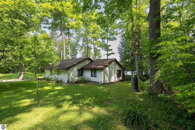 16530 Lonesome Trl, Leroy, MI 49655 - view of property exterior featuring a lawn and roof with shingles