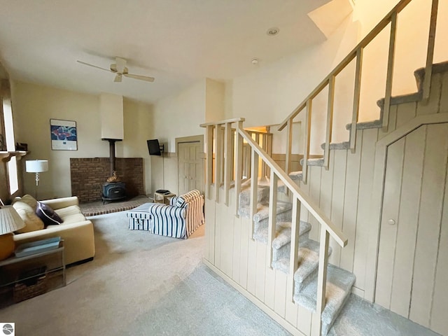407 S Main St, Leland, MI 49654 - staircase featuring a wood stove, carpet floors, and a ceiling fan