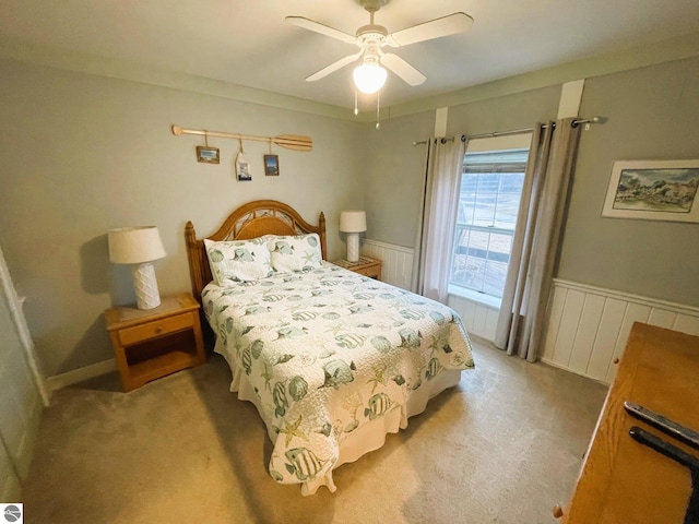 407 S Main St, Leland, MI 49654 - bedroom with a wainscoted wall, light colored carpet, and ceiling fan