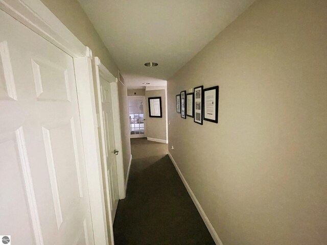 407 S Main St, Leland, MI 49654 - hallway with baseboards and dark colored carpet