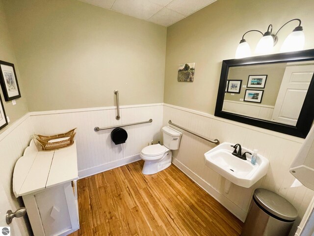 407 S Main St, Leland, MI 49654 - half bathroom with a wainscoted wall and wood finished floors