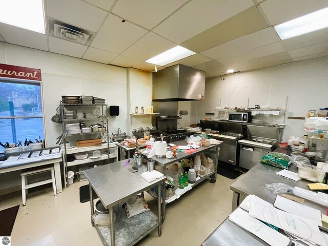 407 S Main St, Leland, MI 49654 - kitchen featuring finished concrete flooring, a drop ceiling, and stainless steel microwave