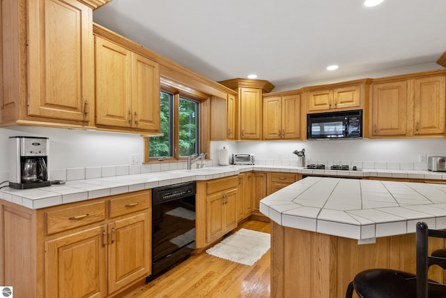 6352 S Westwood Pkwy, Suttons Bay, MI 49682 - kitchen with black appliances, recessed lighting, light wood finished floors, and tile counters
