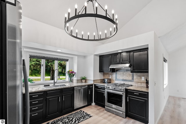 1259 Lin Dale Dr, Traverse City, MI 49686 - kitchen featuring appliances with stainless steel finishes, dark cabinets, under cabinet range hood, light wood-style floors, and high vaulted ceiling
