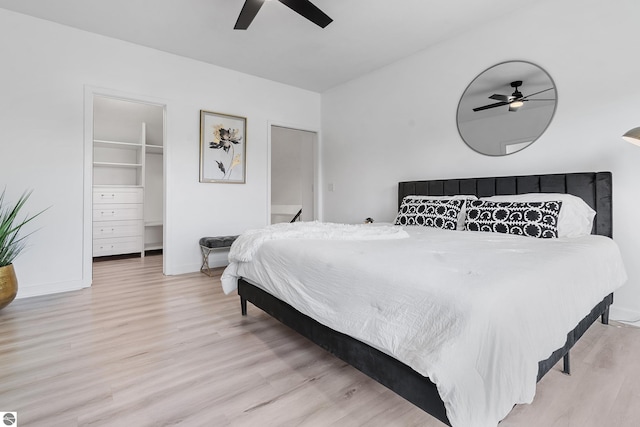 1259 Lin Dale Dr, Traverse City, MI 49686 - bedroom featuring wood finished floors, a walk in closet, a ceiling fan, and a closet