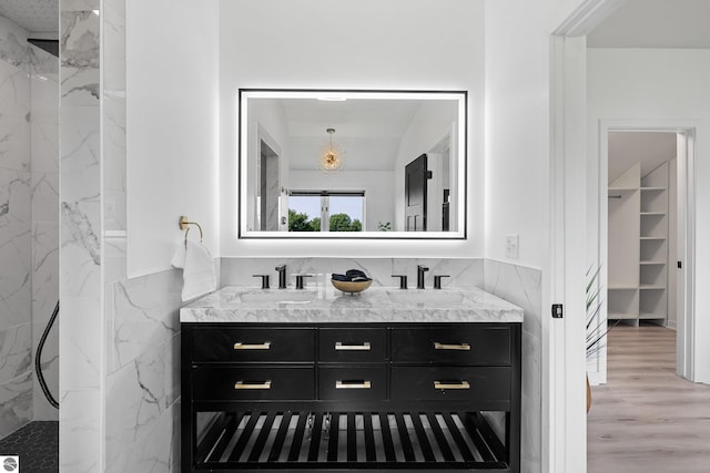 1259 Lin Dale Dr, Traverse City, MI 49686 - full bath with double vanity, a marble finish shower, a spacious closet, and wood finished floors