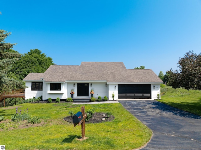 1259 Lin Dale Dr, Traverse City, MI 49686 - ranch-style home featuring a garage, driveway, a front lawn, and a deck
