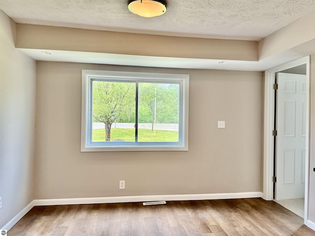 7160 Cherry Ave, Kewadin, MI 49648 - unfurnished room featuring wood finished floors and a textured ceiling