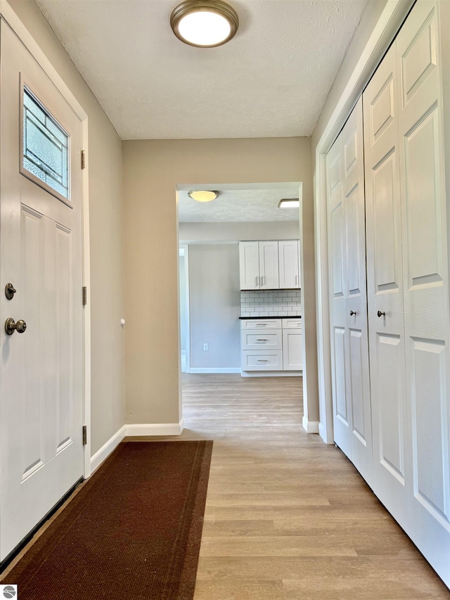 7160 Cherry Ave, Kewadin, MI 49648 - foyer with light wood finished floors and a textured ceiling