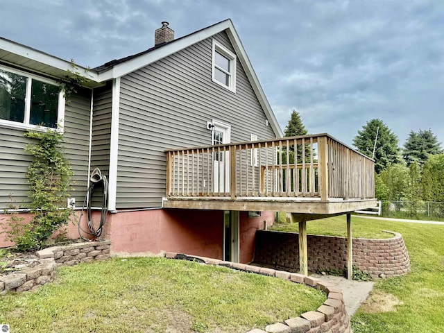 7160 Cherry Ave, Kewadin, MI 49648 - rear view of property with a wooden deck, a chimney, and a yard