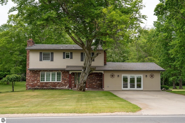 10200 S Lake Station Ave, Lake, MI 48632 - traditional-style house with a chimney, concrete driveway, a front yard, and brick siding