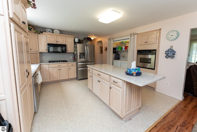 10200 S Lake Station Ave, Lake, MI 48632 - kitchen featuring black appliances, arched walkways, light countertops, and separate washer and dryer