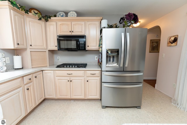 10200 S Lake Station Ave, Lake, MI 48632 - kitchen featuring stainless steel fridge, black microwave, gas stovetop, light tile patterned floors, and arched walkways
