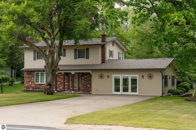 10200 S Lake Station Ave, Lake, MI 48632 - view of front of house featuring a chimney, driveway, a front yard, and brick siding