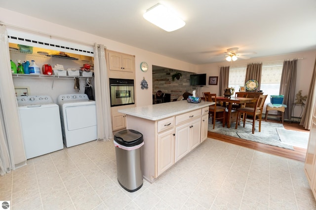 10200 S Lake Station Ave, Lake, MI 48632 - kitchen featuring stainless steel oven, washing machine and clothes dryer, light countertops, ceiling fan, and a center island