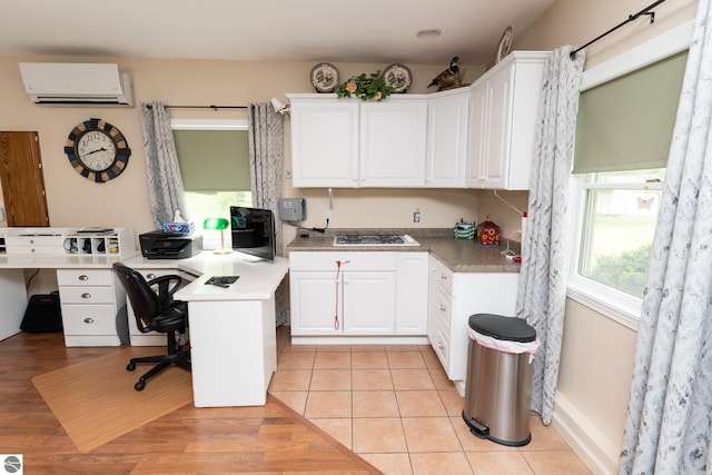 10200 S Lake Station Ave, Lake, MI 48632 - kitchen with a wall mounted air conditioner, white cabinets, a peninsula, an office area, and light tile patterned floors
