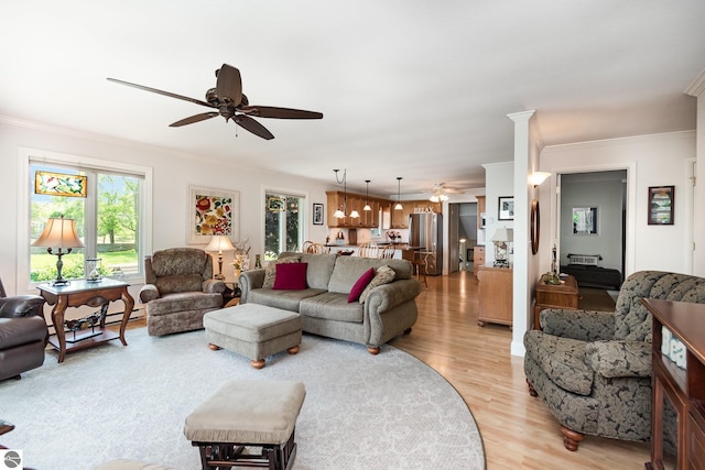 589 Pine Ln, East Tawas, MI 48730 - living room with ceiling fan, ornamental molding, and light wood-style flooring