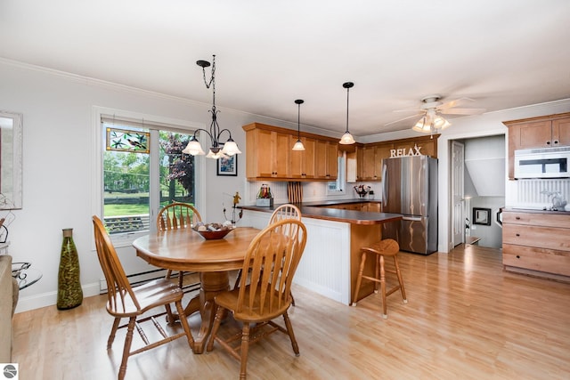 589 Pine Ln, East Tawas, MI 48730 - dining area with light wood-style floors, a chandelier, a ceiling fan, and ornamental molding