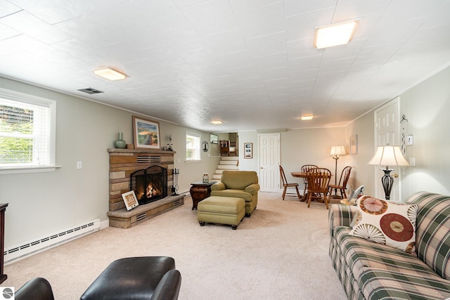 589 Pine Ln, East Tawas, MI 48730 - living room with a baseboard heating unit, stairway, carpet flooring, and a stone fireplace