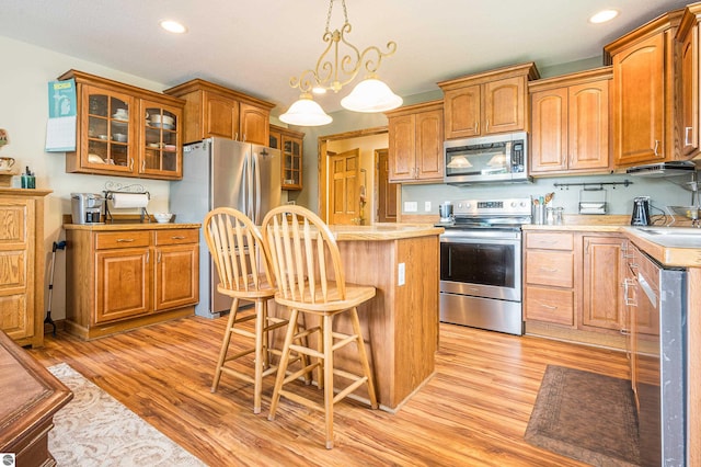 6375 S Isabella Rd, Shepherd, MI 48883 - kitchen featuring appliances with stainless steel finishes, light countertops, a kitchen island, light wood-style floors, and recessed lighting
