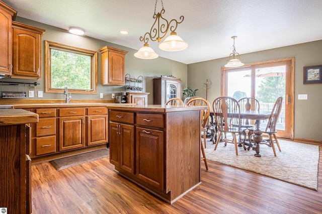 6375 S Isabella Rd, Shepherd, MI 48883 - kitchen with wood finished floors, healthy amount of natural light, a center island, and decorative light fixtures