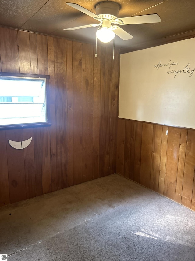 832 Manor Ln, Traverse City, MI 49686 - empty room with carpet, wooden walls, and ceiling fan