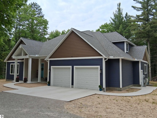 1379 Kunze Rd, East Tawas, MI 48730 - view of front facade featuring driveway, an attached garage, roof with shingles, and covered porch