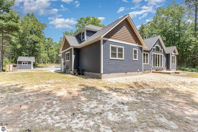 1379 Kunze Rd, East Tawas, MI 48730 - view of property exterior featuring a storage unit and a shingled roof