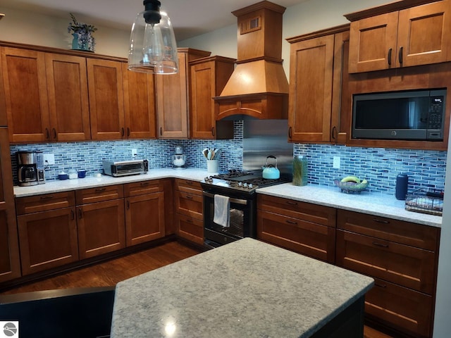 1379 Kunze Rd, East Tawas, MI 48730 - kitchen featuring gas range oven, custom range hood, dark wood-style flooring, tasteful backsplash, and light stone counters