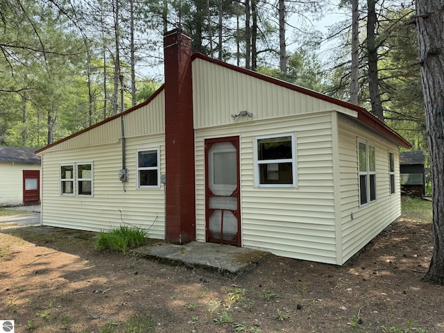 11748 NE Franklin St, Kalkaska, MI 49646 - rear view of property with a chimney