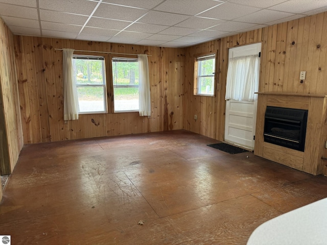 11748 NE Franklin St, Kalkaska, MI 49646 - unfurnished living room featuring wood walls and a glass covered fireplace