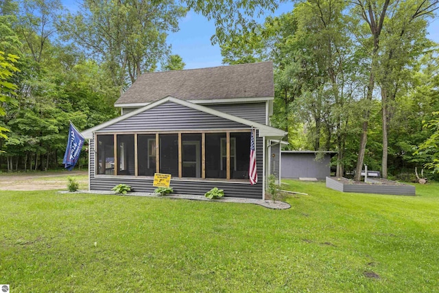 16933 3rd St, Copemish, MI 49625 - rear view of house featuring a sunroom, roof with shingles, and a lawn
