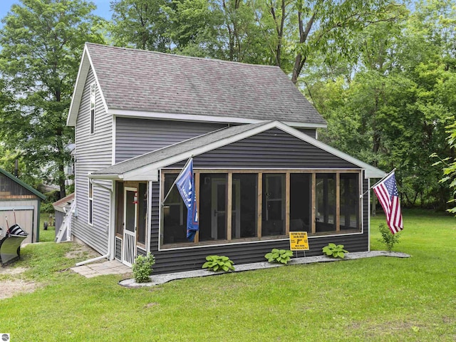 16933 3rd St, Copemish, MI 49625 - rear view of house featuring a shingled roof, a sunroom, and a yard