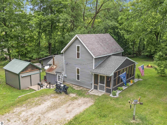 16933 3rd St, Copemish, MI 49625 - back of property with roof with shingles, a sunroom, an outdoor structure, a lawn, and dirt driveway