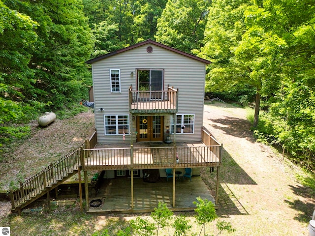 3721 W 18th Rd, Mesick, MI 49668 - rear view of property featuring a deck, stairs, french doors, and a wooded view