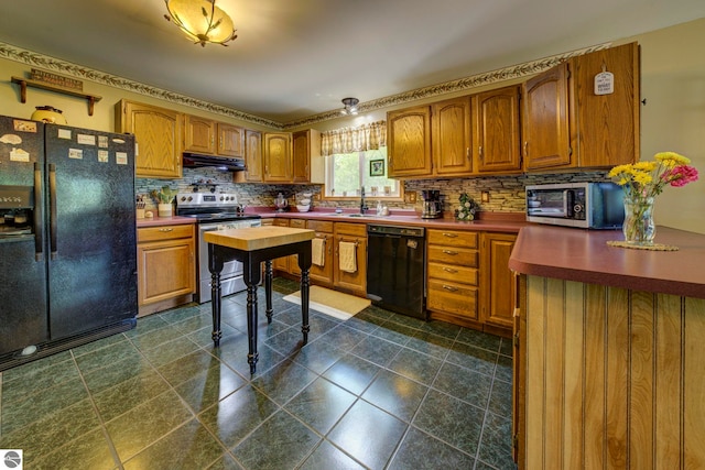 3721 W 18th Rd, Mesick, MI 49668 - kitchen featuring black appliances, under cabinet range hood, brown cabinets, and tasteful backsplash