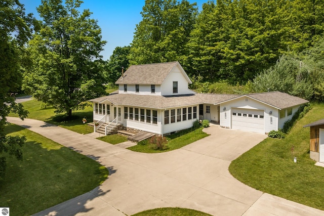 1740 Setterbo Rd, Suttons Bay, MI 49682 - country-style home featuring concrete driveway, roof with shingles, an attached garage, and a front lawn