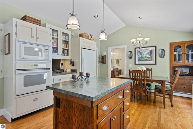 1740 Setterbo Rd, Suttons Bay, MI 49682 - kitchen with white appliances, dark countertops, light wood-type flooring, glass insert cabinets, and vaulted ceiling