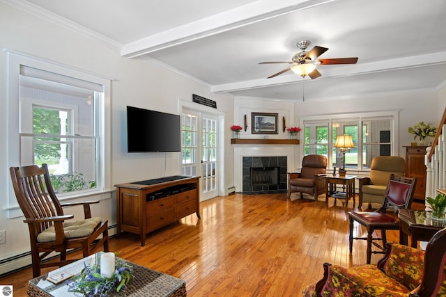 1740 Setterbo Rd, Suttons Bay, MI 49682 - living area featuring a tiled fireplace, beamed ceiling, light wood-style flooring, ceiling fan, and a baseboard heating unit
